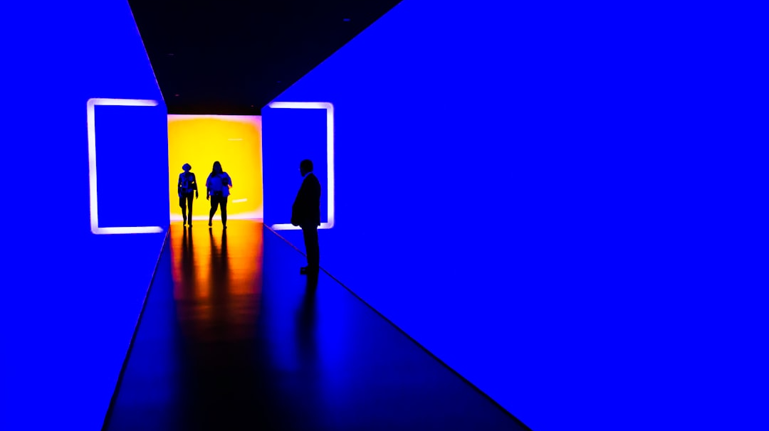 three person standing near wall inside building
